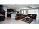 Open living room and kitchen with tile floors, brown sofas, and ceiling fan at 2117 Valterra Vista Way, Valrico, FL 33594