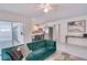 Living room with green velvet sofa, adjacent kitchen, and access to patio at 3275 Fox Hill Dr, Clearwater, FL 33761