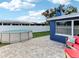 Exterior view of the blue home's backyard with a pool, patio, and outdoor seating area at 4004 Claremont Dr, New Port Richey, FL 34652
