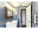 Stylish bathroom with a rustic wood-framed mirror, modern vanity, and cool blue walls at 4004 Claremont Dr, New Port Richey, FL 34652