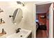 Well-lit bathroom with a large mirror, floating shelves, and a glimpse into the bedroom at 4004 Claremont Dr, New Port Richey, FL 34652