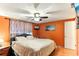 Cozy bedroom with orange walls, a ceiling fan, and bright natural light at 4004 Claremont Dr, New Port Richey, FL 34652