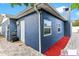 Exterior view of a blue house featuring a brick pathway and well-maintained surroundings at 4004 Claremont Dr, New Port Richey, FL 34652
