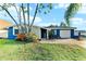 Charming single-story home featuring a stone accent wall, blue paint, and lush landscaping at 4004 Claremont Dr, New Port Richey, FL 34652