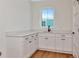 Butler's pantry featuring white cabinets, quartz countertops, modern black hardware, sink, and hardwood flooring at 407 S Albany Ave # 4, Tampa, FL 33606