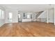 Bright living area showcasing hardwood floors that lead to an open kitchen with a white island and a modern staircase at 407 S Albany Ave # 4, Tampa, FL 33606