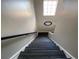 Modern dark wood staircase with a black railing and a clock on the wall at 8337 Lagerfeld Dr, Land O Lakes, FL 34637