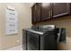 Bright laundry room, featuring modern washer and dryer, and ample cabinetry at 9157 Bella Vita Cir, Land O Lakes, FL 34637