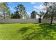 Large grassy backyard with a privacy fence and mature trees at 9157 Bella Vita Cir, Land O Lakes, FL 34637
