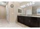 Double sink bathroom with granite countertops and dark brown cabinets at 9157 Bella Vita Cir, Land O Lakes, FL 34637