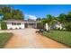 Beautiful home with a large driveway, lush landscaping, and a two-car garage at 440 Mehlenbacher Rd, Belleair, FL 33756