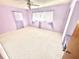 Spacious bedroom with light-purple walls and new carpet at 14018 Thacher Ave, Largo, FL 33774