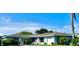 Ranch-style home with a light blue exterior, attached garage, and mature landscaping at 14018 Thacher Ave, Largo, FL 33774