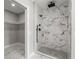 Modern bathroom with a large walk-in shower and marble tile at 211 Dolphin Pt # 202, Clearwater Beach, FL 33767