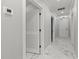 Bright hallway with marble floors and white doors at 211 Dolphin Pt # 202, Clearwater Beach, FL 33767