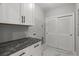 Laundry Room with modern finishes and storage at 211 Dolphin Pt # 202, Clearwater Beach, FL 33767