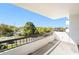 View from the balcony overlooking a quaint neighborhood street with mature trees and a bright, sunny sky at 30 Turner St # 401, Clearwater, FL 33756
