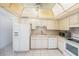 Well-lit kitchen with white appliances, white cabinets and tile flooring at 30 Turner St # 401, Clearwater, FL 33756