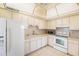 Clean kitchen with white appliances, tile floor and warm lighting at 30 Turner St # 401, Clearwater, FL 33756
