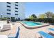 Clean, well-maintained community pool with lounge chairs, mature landscaping, and high-rise building backdrop at 30 Turner St # 401, Clearwater, FL 33756