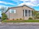 Tan mobile home with screened porch and landscaping at 8676 Fantasia Park Way, Riverview, FL 33578