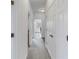Bright hallway with carpet, access to laundry, and bathroom at 11339 Tayport Loop, New Port Richey, FL 34654