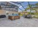 Screened patio with hot tub, seating area, and outdoor kitchen at 11339 Tayport Loop, New Port Richey, FL 34654