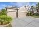 Beige two-story house with three-car garage and lush landscaping at 11339 Tayport Loop, New Port Richey, FL 34654
