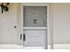 White front door with screen door and number 202 at 820 Virginia St # 202, Dunedin, FL 34698