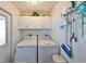 Bright laundry room with white cabinets, washer, and dryer at 701 Desert Hills Way, Sun City Center, FL 33573