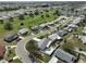 Aerial view showcasing a neighborhood with houses, roads, and a central green space at 701 Desert Hills Way, Sun City Center, FL 33573