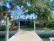 Exterior shot of a home featuring a wooden dock extending into the water with mature trees surrounding the property at 1943 Bayou Grande Ne Blvd, St Petersburg, FL 33703