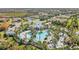 Aerial view of the community pool, clubhouse, and surrounding homes in a lushly landscaped neighborhood at 26810 Weiskopf Dr, Englewood, FL 34223