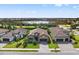 Beautifully landscaped home with a paver driveway and a lush green lawn overlooking a serene lake at 26810 Weiskopf Dr, Englewood, FL 34223
