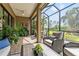 Relaxing screened lanai featuring comfortable seating, a ceiling fan, and views of the surrounding greenery at 26810 Weiskopf Dr, Englewood, FL 34223