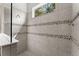 Modern shower with tiled walls, mosaic accents, and a bright window at 26810 Weiskopf Dr, Englewood, FL 34223