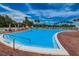 Community pool with lounge chairs and red umbrellas at 3942 Trophy Blvd, New Port Richey, FL 34655