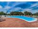 Community pool with lounge chairs and red umbrellas at 3942 Trophy Blvd, New Port Richey, FL 34655