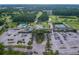 Aerial view of community clubhouse, pool, tennis courts, and parking lot at 3942 Trophy Blvd, New Port Richey, FL 34655