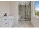 Bright bathroom featuring a white marble floor, black hardware, and a glass-enclosed shower at 407 S Albany Ave # 2, Tampa, FL 33606