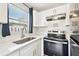 Modern kitchen with white cabinets, stainless steel appliances, and quartz countertops at 7125 Colfax Dr, Port Richey, FL 34668