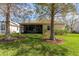 Home's backyard features a large screened patio, lush lawn, and mature trees at 5195 Highbury Cir, Sarasota, FL 34238