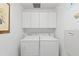 Convenient laundry room with washer, dryer, and overhead cabinets at 5195 Highbury Cir, Sarasota, FL 34238