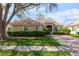 Single-story home with a tile roof, landscaped yard, and a paved driveway at 5195 Highbury Cir, Sarasota, FL 34238