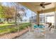 Relaxing screened porch overlooks a pond with seating for four and ceiling fan at 5195 Highbury Cir, Sarasota, FL 34238