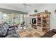 Bright living room featuring comfy leather sofas, a large entertainment center, and sliding glass doors leading to the backyard at 5195 Highbury Cir, Sarasota, FL 34238