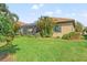 Screened patio and grassy backyard with palm trees at 26810 Weiskopf Dr, Englewood, FL 34223