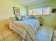 Comfortable bedroom with striped bedding and large window at 1701 Pinehurst Rd # 8B, Dunedin, FL 34698