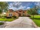 Two-story house with terracotta tile roof, landscaped yard, and a three-car garage at 20103 Shady Hill Ln, Tampa, FL 33647