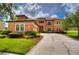 Two-story house with terracotta tile roof, landscaped yard, and a three-car garage at 20103 Shady Hill Ln, Tampa, FL 33647